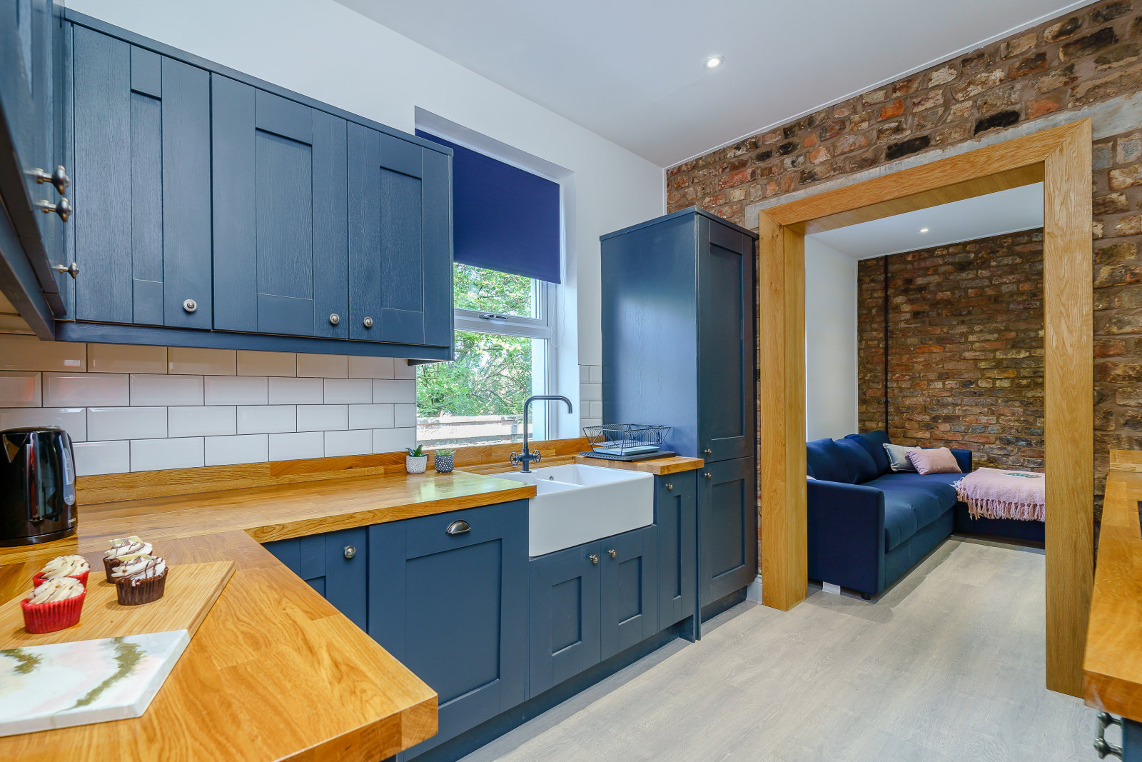 Renovated kitchen with blue cabinets opening onto a sitting area